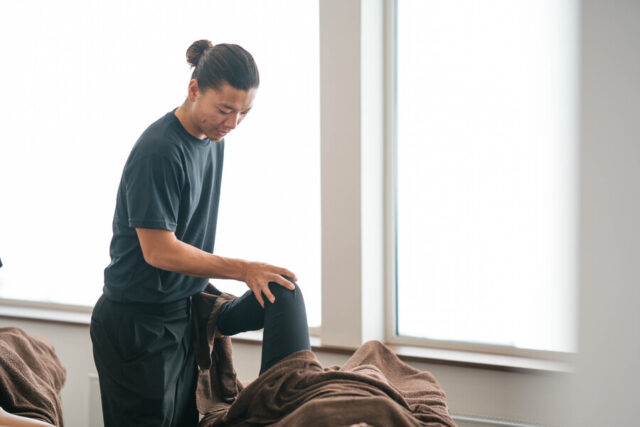 北海道ニセコでのドライマッサージ。筋肉をほぐし可動域を広げる下半身のストレッチ施術